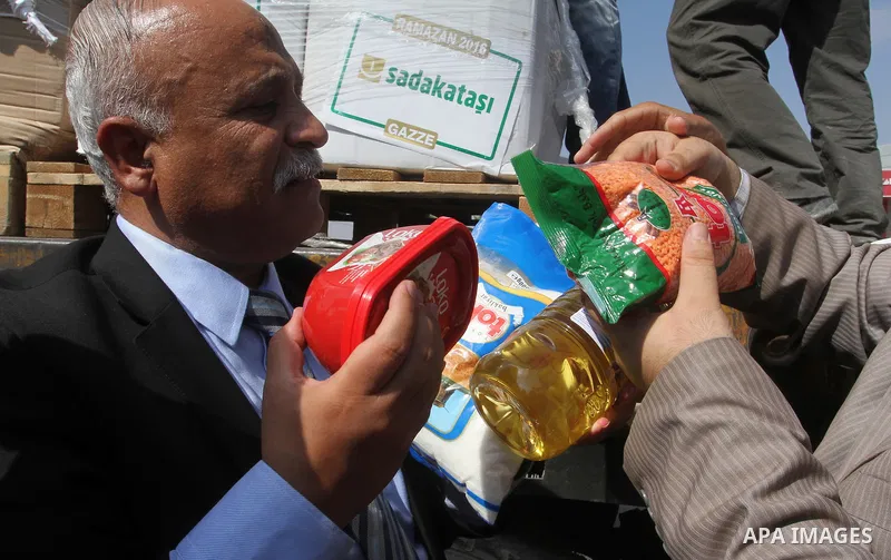 Undersecretary of the ministry of social affairs in Gaza, Yousef Ibrahim, shows contents of humanitarian aid parcels provided by Turkey to the press after it entered the southern Gaza Strip from Israel through the Kerem...