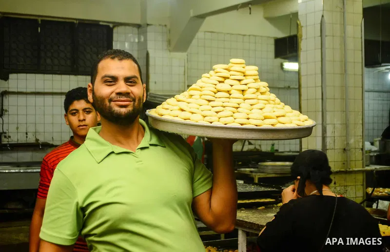 Egyptian bakers prepare date-filled mini cakes traditional for the Eid al-Fitr a three-day holiday that marks the end of the fasting month of Ramadan, at shop in Cairo, Egypt, on July 4, 2016, as Muslims the world over p...