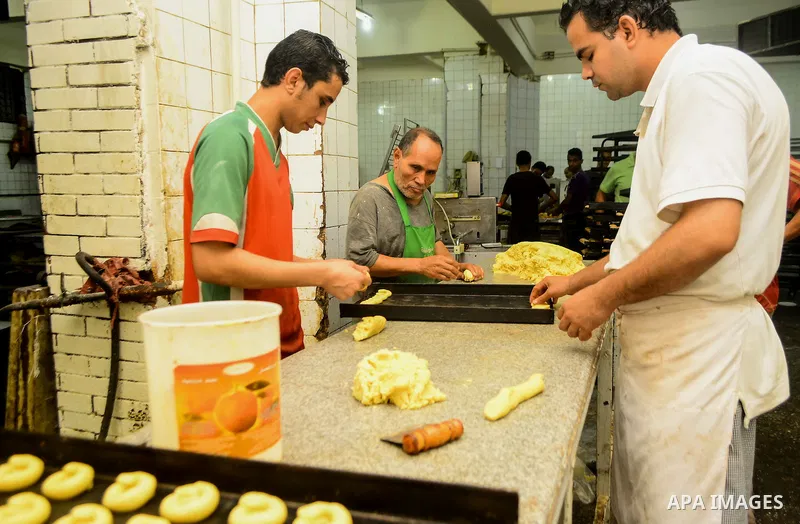 Egyptian bakers prepare date-filled mini cakes traditional for the Eid al-Fitr a three-day holiday that marks the end of the fasting month of Ramadan, at shop in Cairo, Egypt, on July 4, 2016, as Muslims the world over p...