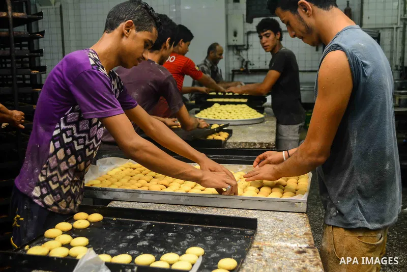 Egyptian bakers prepare date-filled mini cakes traditional for the Eid al-Fitr a three-day holiday that marks the end of the fasting month of Ramadan, at shop in Cairo, Egypt, on July 4, 2016, as Muslims the world over p...
