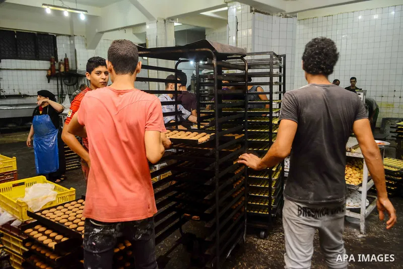 Egyptian bakers prepare date-filled mini cakes traditional for the Eid al-Fitr a three-day holiday that marks the end of the fasting month of Ramadan, at shop in Cairo, Egypt, on July 4, 2016, as Muslims the world over p...