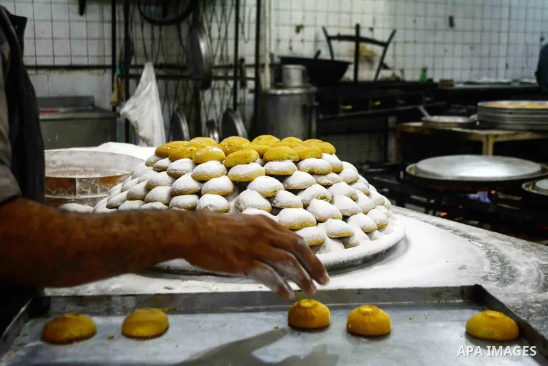 Egyptian bakers prepare date-filled mini cakes traditional for the Eid al-Fitr a three-day holiday that marks the end of the fasting month of Ramadan, at shop in Cairo, Egypt, on July 4, 2016, as Muslims the world over p...