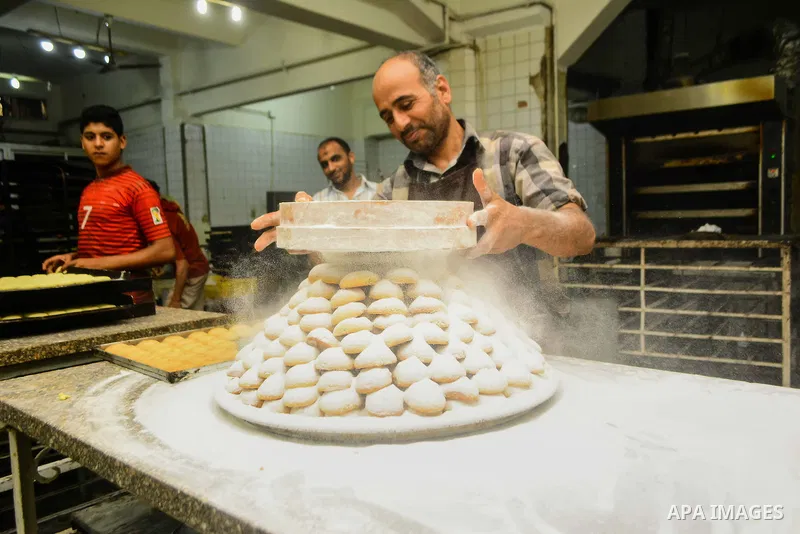 Egyptian bakers prepare date-filled mini cakes traditional for the Eid al-Fitr a three-day holiday that marks the end of the fasting month of Ramadan, at shop in Cairo, Egypt, on July 4, 2016, as Muslims the world over p...