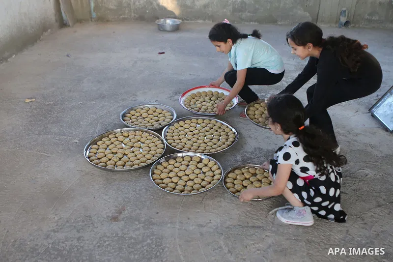 Palestinian girls prepare date-filled mini cakes traditional ahead of the Eid al-Fitr holiday in the West Bank city of Ramallah, on July 05, 2016, as Muslims the world over prepare to celebrate Eid al-Fitr, starting with...