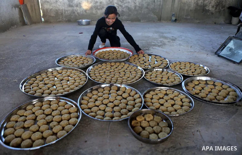 Palestinian girls prepare date-filled mini cakes traditional ahead of the Eid al-Fitr holiday in the West Bank city of Ramallah, on July 05, 2016, as Muslims the world over prepare to celebrate Eid al-Fitr, starting with...