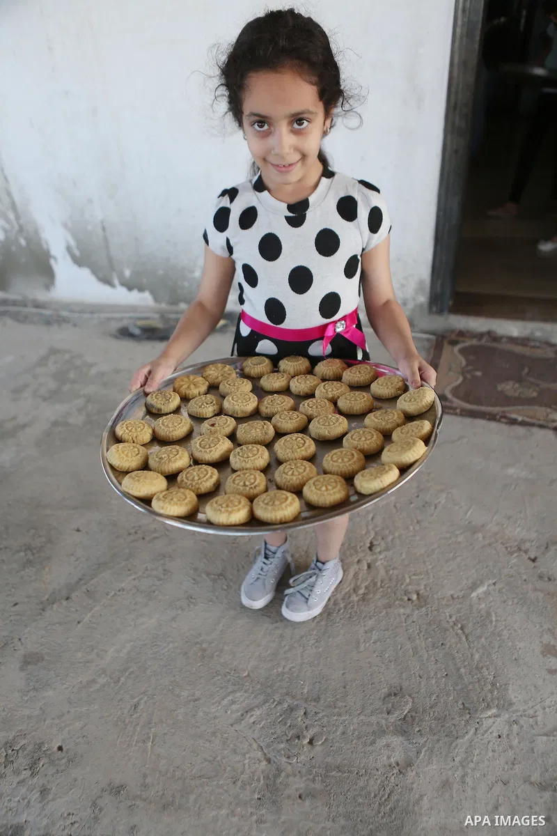 A Palestinian girl prepares date-filled mini cakes traditional ahead of the Eid al-Fitr holiday in the West Bank city of Ramallah, on July 05, 2016, as Muslims the world over prepare to celebrate Eid al-Fitr, starting wi...