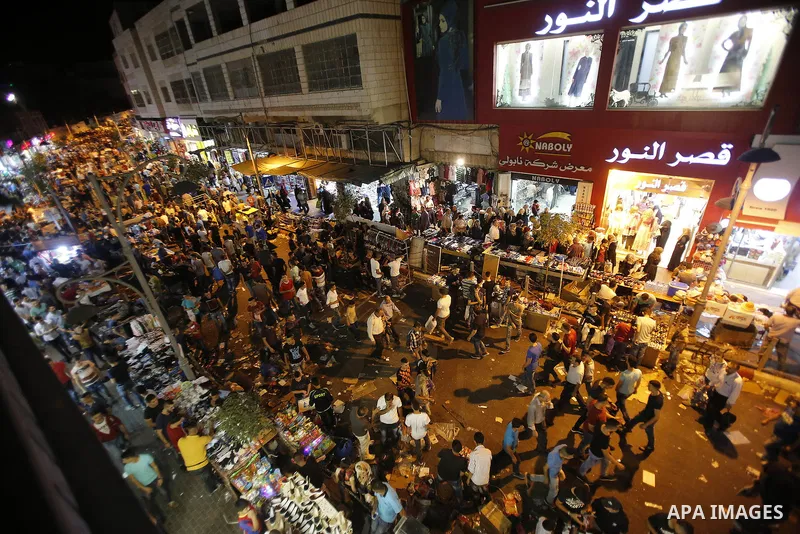 Palestinians shop at market ahead of the Eid al-Fitr holiday in the West Bank city of Hebron, on July 05, 2016, as Muslims the world over prepare to celebrate Eid al-Fitr, starting with the with the sighting of the new m...
