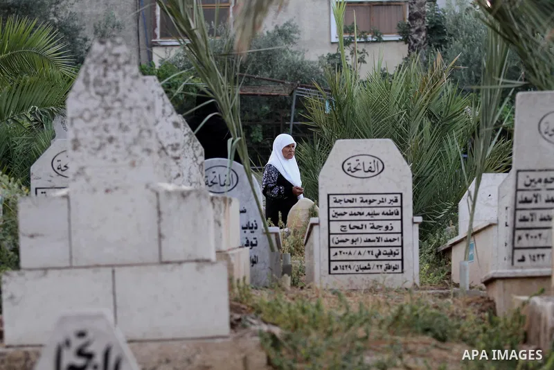 Palestinian women visit the graves of relatives at a cemetery on the first day of Eid al-Fitr celebrations, which marks the end of the holy fasting month of Ramadan, in the West Bank city of Nablus, on July 6, 2016. Phot...