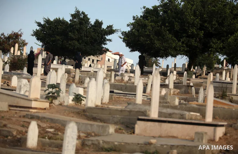 Palestinians visit the grave of their relative at a cemetery on the first day of Eid al-Fitr celebrations, which marks the end of the holy fasting month of Ramadan, in Gaza City July 6, 2016. Photo by Ashraf Amra