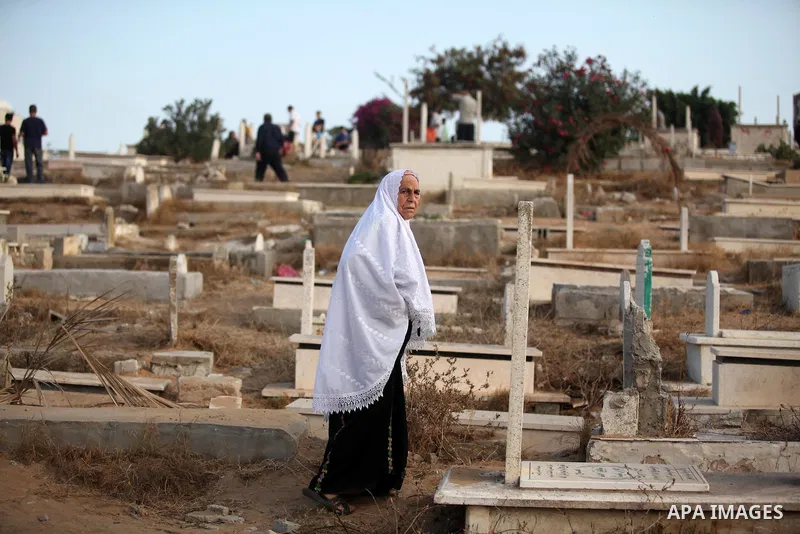 A Palestinian woman visits the grave of her relative at a cemetery on the first day of Eid al-Fitr celebrations, which marks the end of the holy fasting month of Ramadan, in Gaza City July 6, 2016. Photo by Ashraf Amra