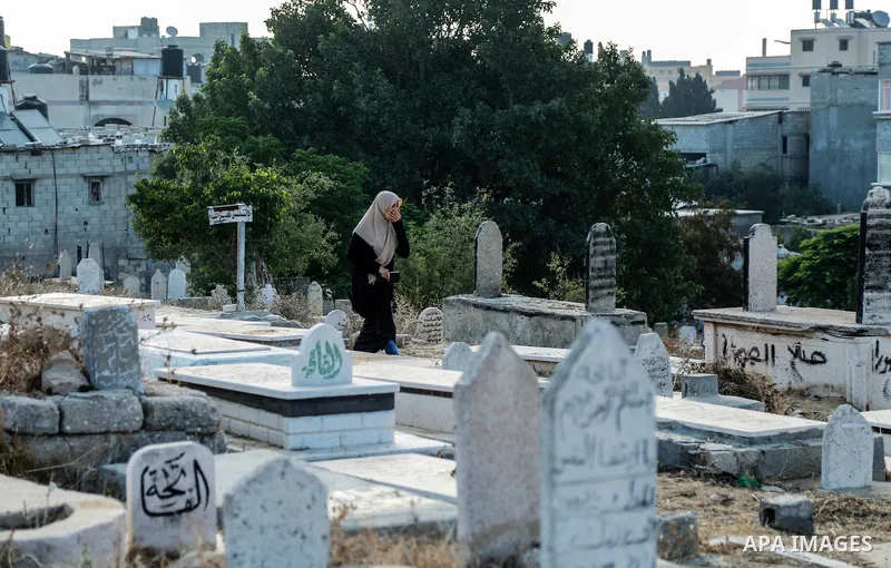 A Palestinian woman visits the grave of her relative at a cemetery on the first day of Eid al-Fitr celebrations, which marks the end of the holy fasting month of Ramadan, in Gaza City July 6, 2016. Photo by Mohammed Dahm...