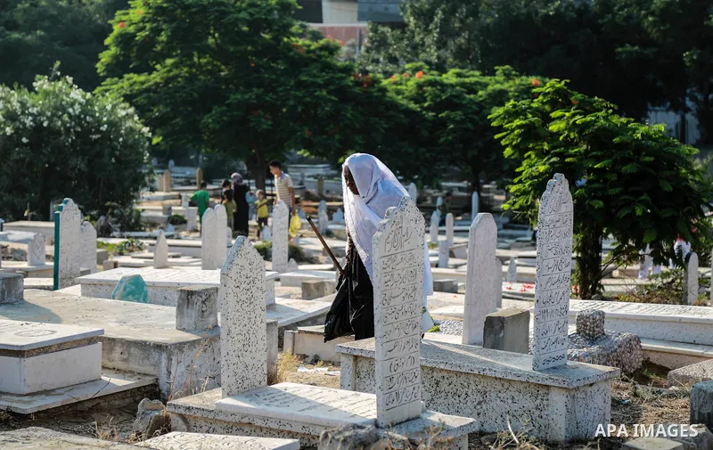 A Palestinian woman visits the grave of her relative at a cemetery on the first day of Eid al-Fitr celebrations, which marks the end of the holy fasting month of Ramadan, in Gaza City July 6, 2016. Photo by Mohammed Dahm...