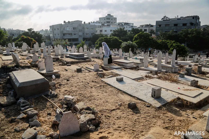 A Palestinian woman visits the grave of her relative at a cemetery on the first day of Eid al-Fitr celebrations, which marks the end of the holy fasting month of Ramadan, in Gaza City July 6, 2016. Photo by Mohammed Dahm...
