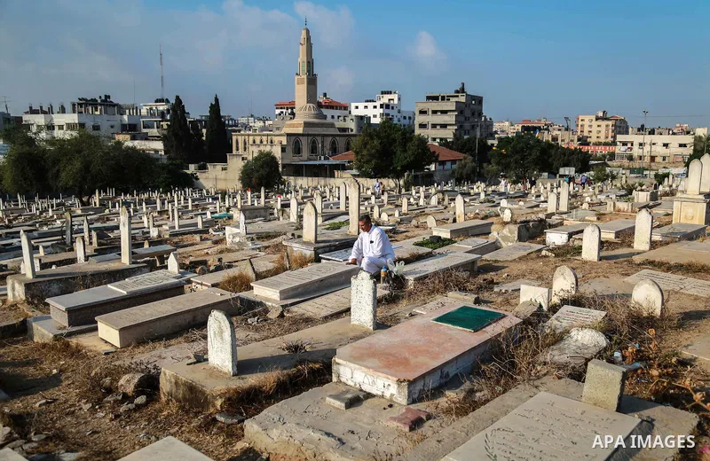 A Palestinian man visits the grave of his relative at a cemetery on the first day of Eid al-Fitr celebrations, which marks the end of the holy fasting month of Ramadan, in Gaza City July 6, 2016. Photo by Mohammed Dahman