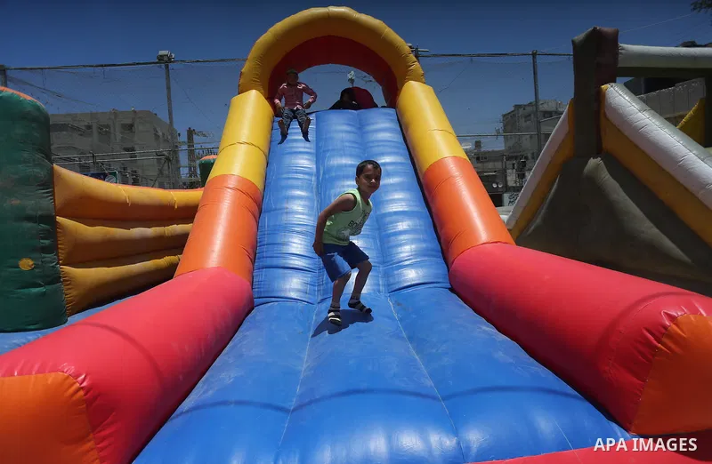 Palestinian children play on the second day of of Eid al-Fitr celebrations, which marks the end of the holy fasting month of Ramadan, at the al-Shati refugee camp in Gaza City on July 7, 2016. Photo by Mohammed Asad