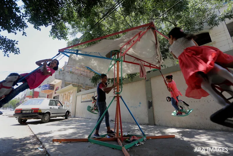 Palestinian children play on the second day of of Eid al-Fitr celebrations, which marks the end of the holy fasting month of Ramadan, at the al-Shati refugee camp in Gaza City on July 7, 2016. Photo by Mohammed Asad