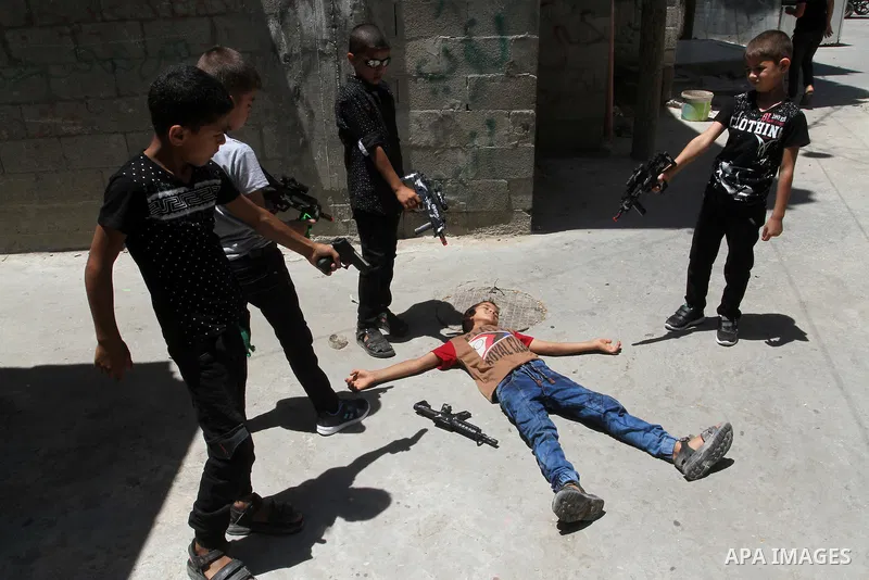 Palestinian boys play with toy guns to celebrate Eid al-Fitr during the second day of the holiday of Eid al-Fitr marking the end of Islam's fasting holy month of Ramadan, in Rafah in the southern Gaza strip, on July 7, 2...