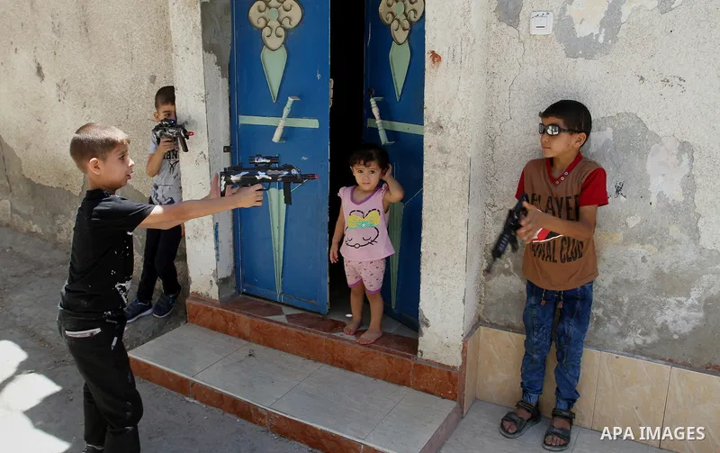 Palestinian boys play with toy guns to celebrate Eid al-Fitr during the second day of the holiday of Eid al-Fitr marking the end of Islam's fasting holy month of Ramadan, in Rafah in the southern Gaza strip, on July 7, 2...