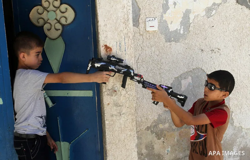 Palestinian boys play with toy guns to celebrate Eid al-Fitr during the second day of the holiday of Eid al-Fitr marking the end of Islam's fasting holy month of Ramadan, in Rafah in the southern Gaza strip, on July 7, 2...