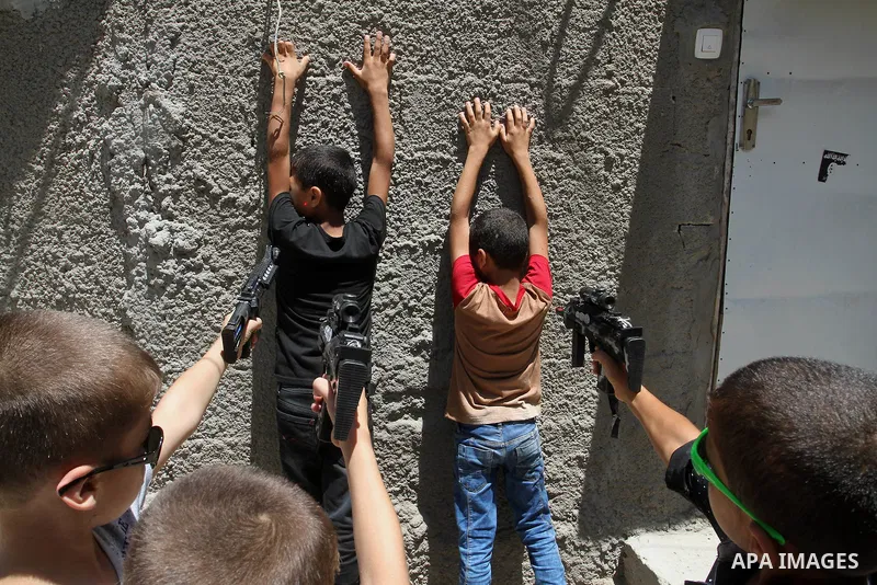 Palestinian boys play with toy guns to celebrate Eid al-Fitr during the second day of the holiday of Eid al-Fitr marking the end of Islam's fasting holy month of Ramadan, in Rafah in the southern Gaza strip, on July 7, 2...
