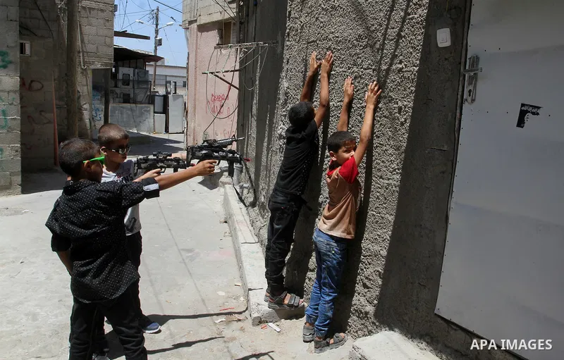 Palestinian boys play with toy guns to celebrate Eid al-Fitr during the second day of the holiday of Eid al-Fitr marking the end of Islam's fasting holy month of Ramadan, in Rafah in the southern Gaza strip, on July 7, 2...