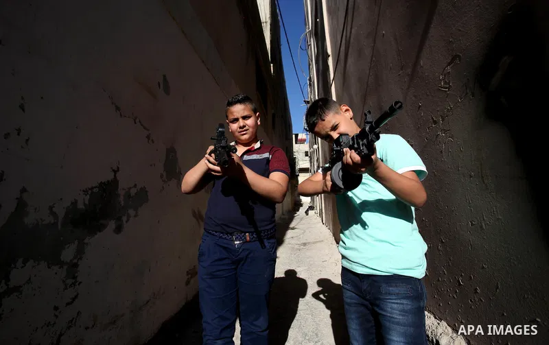 Palestinian boys play with toy guns to celebrate Eid al-Fitr during the second day of the holiday of Eid al-Fitr marking the end of Islam's fasting holy month of Ramadan, in the West Bank city of Nablus, on July 7, 2016....