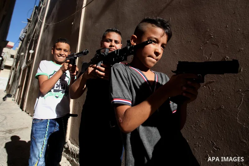 Palestinian boys play with toy guns to celebrate Eid al-Fitr during the second day of the holiday of Eid al-Fitr marking the end of Islam's fasting holy month of Ramadan, in the West Bank city of Nablus, on July 7, 2016....