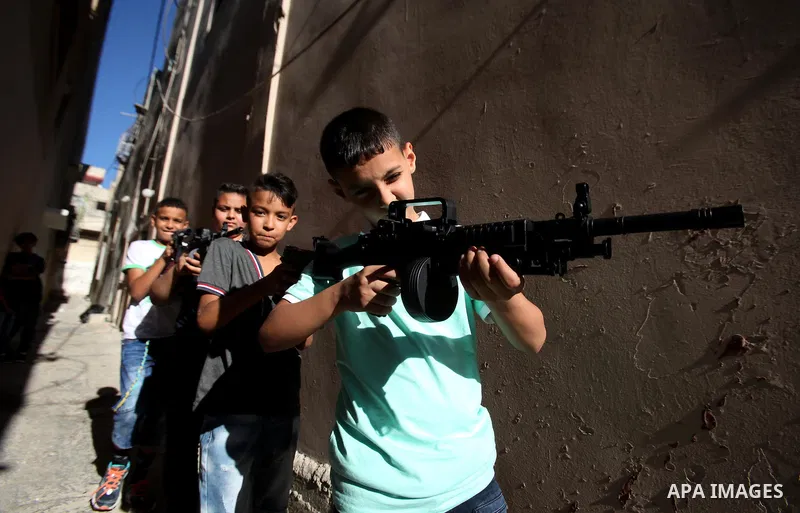 Palestinian boys play with toy guns to celebrate Eid al-Fitr during the second day of the holiday of Eid al-Fitr marking the end of Islam's fasting holy month of Ramadan, in the West Bank city of Nablus, on July 7, 2016....