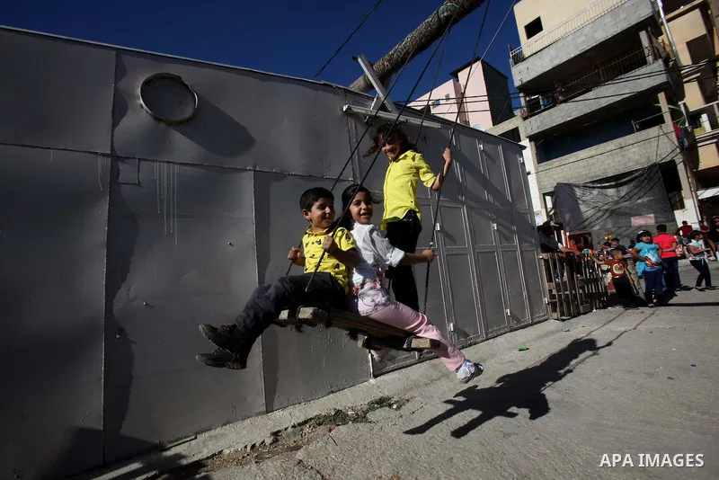 Palestinian children play to celebrate Eid al-Fitr during the second day of the holiday of Eid al-Fitr marking the end of Islam's fasting holy month of Ramadan, in the West Bank city of Nablus, on July 7, 2016. Photo by...