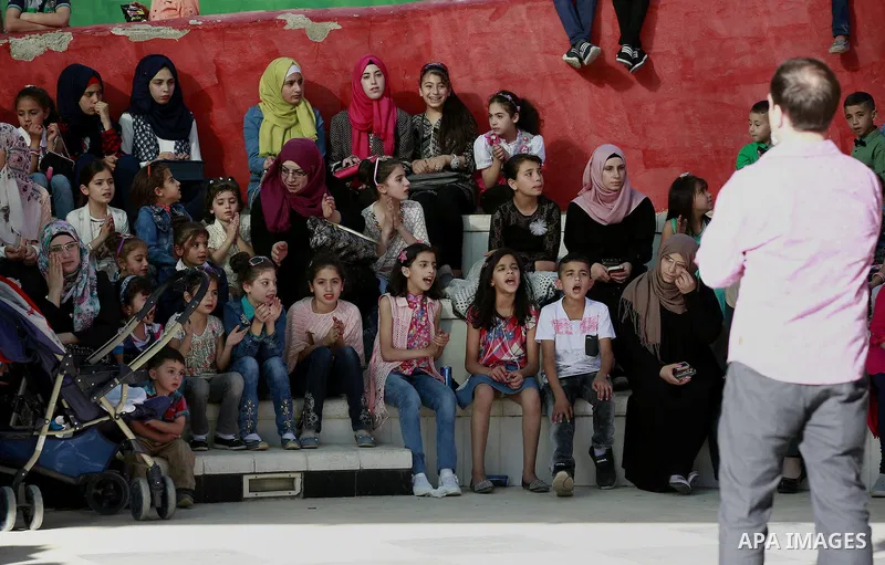Palestinian children play to celebrate Eid al-Fitr during the second day of the holiday of Eid al-Fitr marking the end of Islam's fasting holy month of Ramadan, in the West Bank city of Hebron, on July 7, 2016. Photo by...
