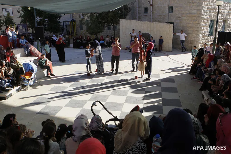 Palestinian children play to celebrate Eid al-Fitr during the second day of the holiday of Eid al-Fitr marking the end of Islam's fasting holy month of Ramadan, in the West Bank city of Hebron, on July 7, 2016. Photo by...