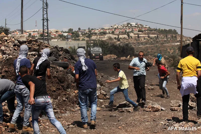 Palestinian protesters hurl stones towards Israeli security forces during clashes following a demonstration against the expropriation of Palestinian land by Israel on July 08, 2016 in the village of Kfar Qaddum, near Nab...