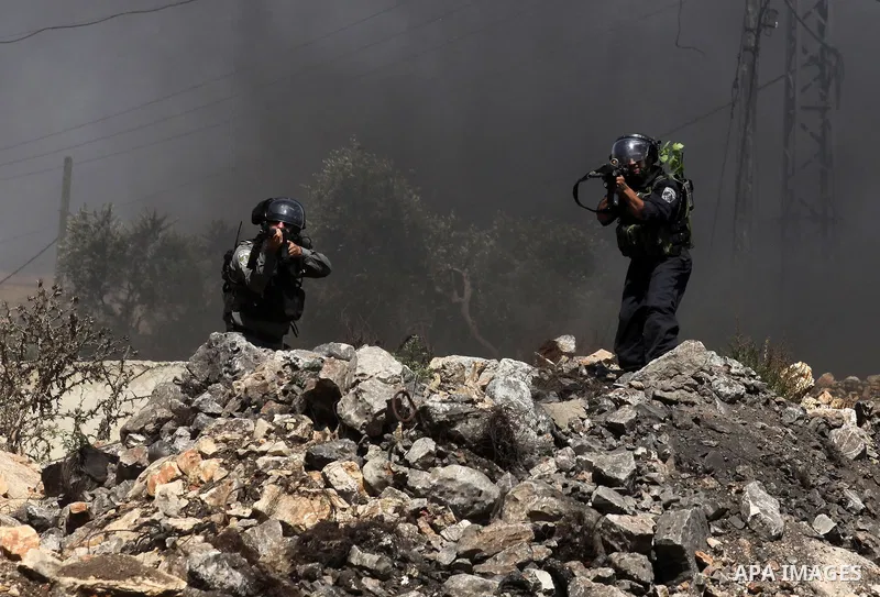 Israeli security forces aim their weapons at Palestinian protesters during clashes following a demonstration against the expropriation of Palestinian land by Israel on July 08, 2016 in the village of Kfar Qaddum, near Na...