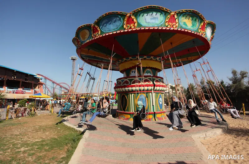 Palestinians take a ride at an amusement park on the third day of Eid al-Fitr holiday which marks the end of the Muslim holy month of Ramadan, in Gaza City on July 08, 2016. Photo by Ashraf Amra