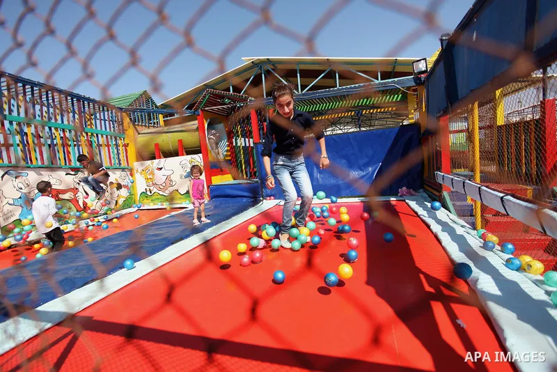 Palestinian children play at an amusement park on the third day of Eid al-Fitr holiday which marks the end of the Muslim holy month of Ramadan, in Gaza City on July 08, 2016. Photo by Ashraf Amra