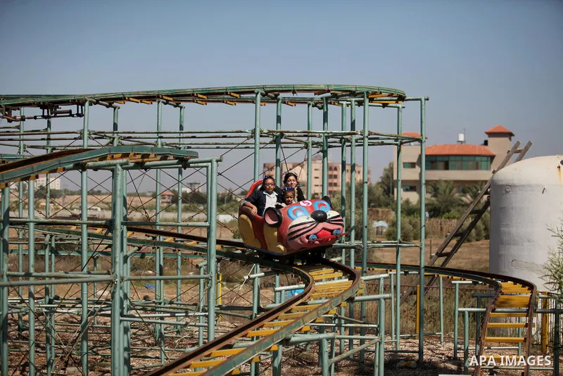Palestinians take a ride at an amusement park on the third day of Eid al-Fitr holiday which marks the end of the Muslim holy month of Ramadan, in Gaza City on July 08, 2016. Photo by Ashraf Amra