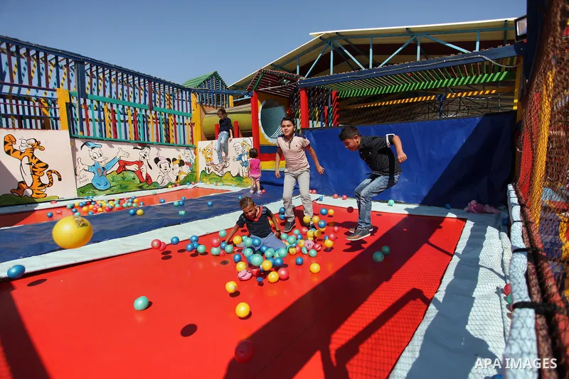 Palestinian children play at an amusement park on the third day of Eid al-Fitr holiday which marks the end of the Muslim holy month of Ramadan, in Gaza City on July 08, 2016. Photo by Ashraf Amra