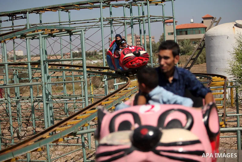 Palestinians take a ride at an amusement park on the third day of Eid al-Fitr holiday which marks the end of the Muslim holy month of Ramadan, in Gaza City on July 08, 2016. Photo by Ashraf Amra