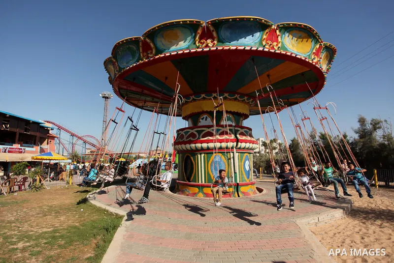 Palestinians take a ride at an amusement park on the third day of Eid al-Fitr holiday which marks the end of the Muslim holy month of Ramadan, in Gaza City on July 08, 2016. Photo by Ashraf Amra