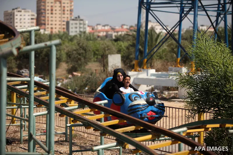 Palestinians take a ride at an amusement park on the third day of Eid al-Fitr holiday which marks the end of the Muslim holy month of Ramadan, in Gaza City on July 08, 2016. Photo by Ashraf Amra