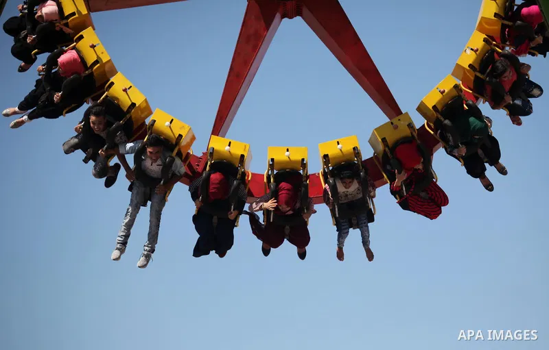 Palestinians take a ride at an amusement park on the third day of Eid al-Fitr holiday which marks the end of the Muslim holy month of Ramadan, in Gaza City on July 08, 2016. Photo by Ashraf Amra