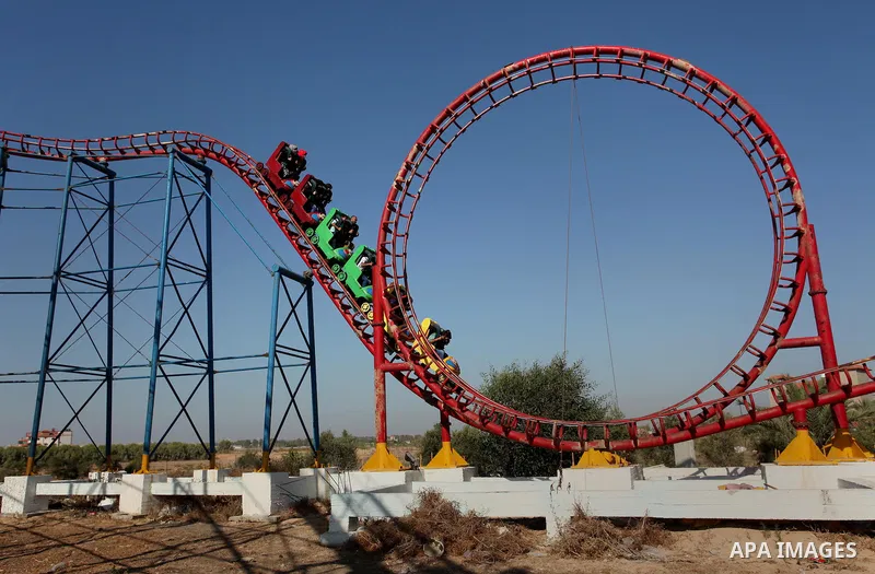 Palestinians take a ride at an amusement park on the third day of Eid al-Fitr holiday which marks the end of the Muslim holy month of Ramadan, in Gaza City on July 08, 2016. Photo by Ashraf Amra