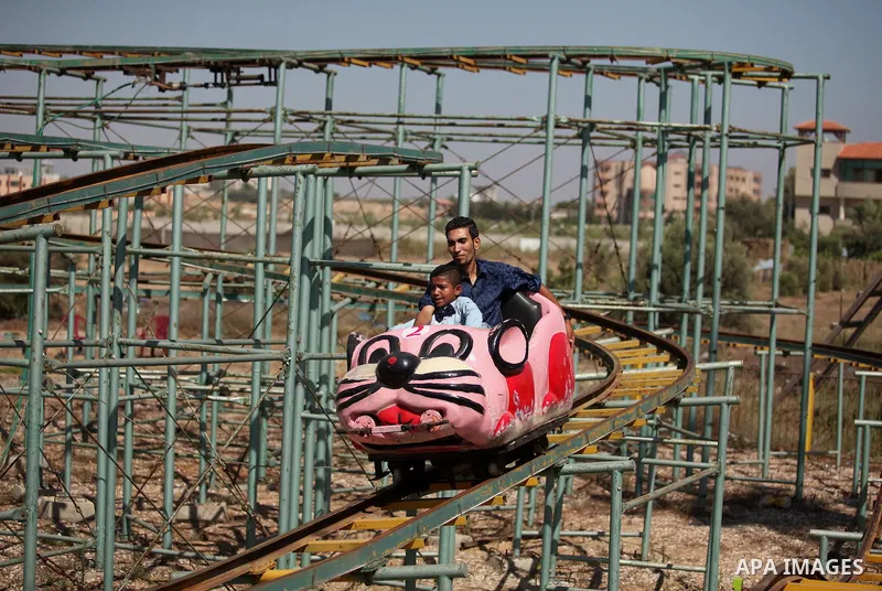 Palestinians take a ride at an amusement park on the third day of Eid al-Fitr holiday which marks the end of the Muslim holy month of Ramadan, in Gaza City on July 08, 2016. Photo by Ashraf Amra