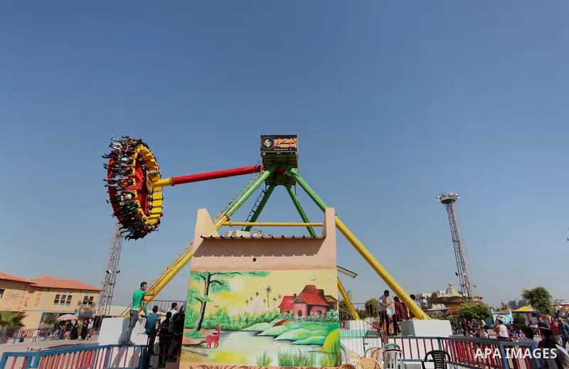 Palestinians take a ride at an amusement park on the third day of Eid al-Fitr holiday which marks the end of the Muslim holy month of Ramadan, in Gaza City on July 08, 2016. Photo by Ashraf Amra