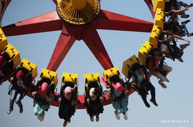 Palestinians take a ride at an amusement park on the third day of Eid al-Fitr holiday which marks the end of the Muslim holy month of Ramadan, in Gaza City on July 08, 2016. Photo by Ashraf Amra