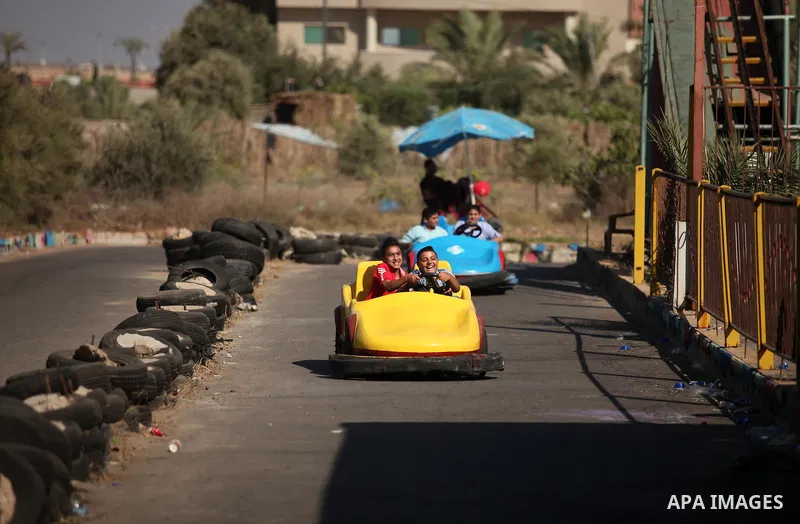 Palestinian children ride bumper car at an amusement park on the third day of Eid al-Fitr holiday which marks the end of the Muslim holy month of Ramadan, in Gaza City on July 08, 2016. Photo by Ashraf Amra