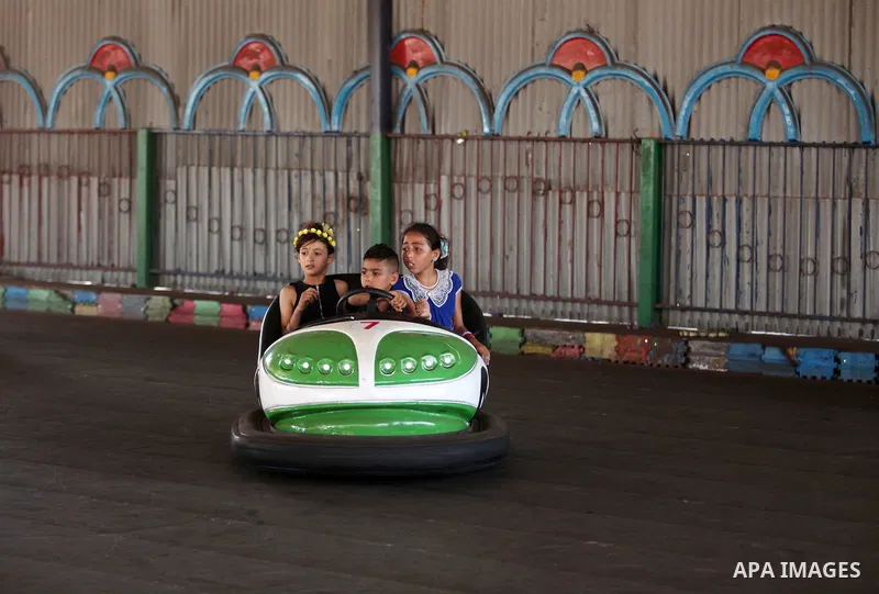 Palestinian children ride bumper car at an amusement park on the third day of Eid al-Fitr holiday which marks the end of the Muslim holy month of Ramadan, in Gaza City on July 08, 2016. Photo by Ashraf Amra