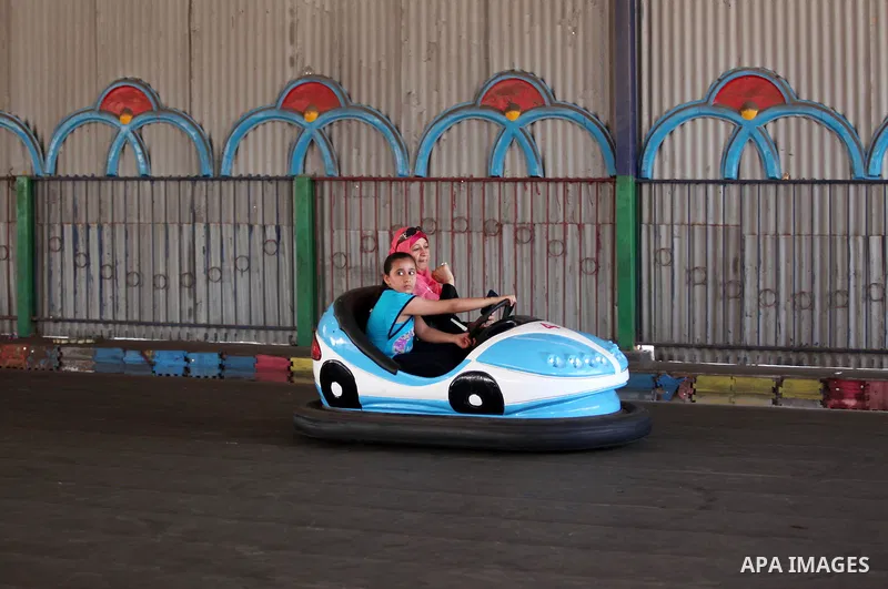 Palestinian children ride bumper car at an amusement park on the third day of Eid al-Fitr holiday which marks the end of the Muslim holy month of Ramadan, in Gaza City on July 08, 2016. Photo by Ashraf Amra