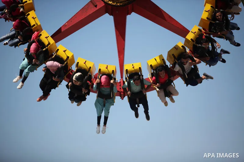 Palestinians take a ride at an amusement park on the third day of Eid al-Fitr holiday which marks the end of the Muslim holy month of Ramadan, in Gaza City on July 08, 2016. Photo by Ashraf Amra