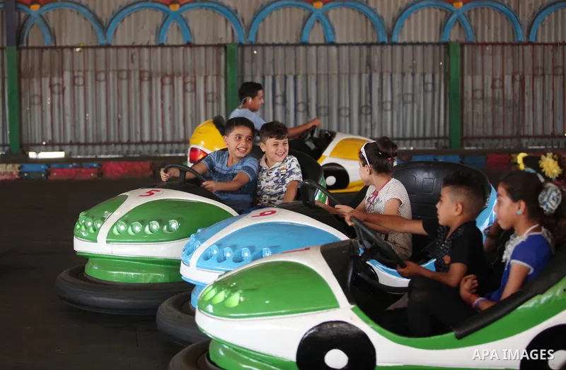 Palestinian children ride bumper car at an amusement park on the third day of Eid al-Fitr holiday which marks the end of the Muslim holy month of Ramadan, in Gaza City on July 08, 2016. Photo by Ashraf Amra